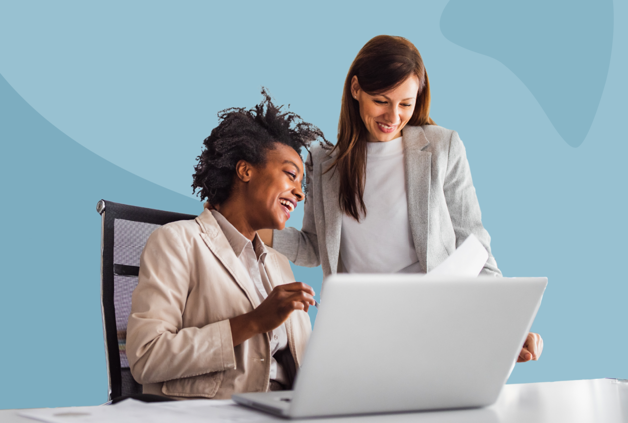 Male and female looking at a laptop together smiling.