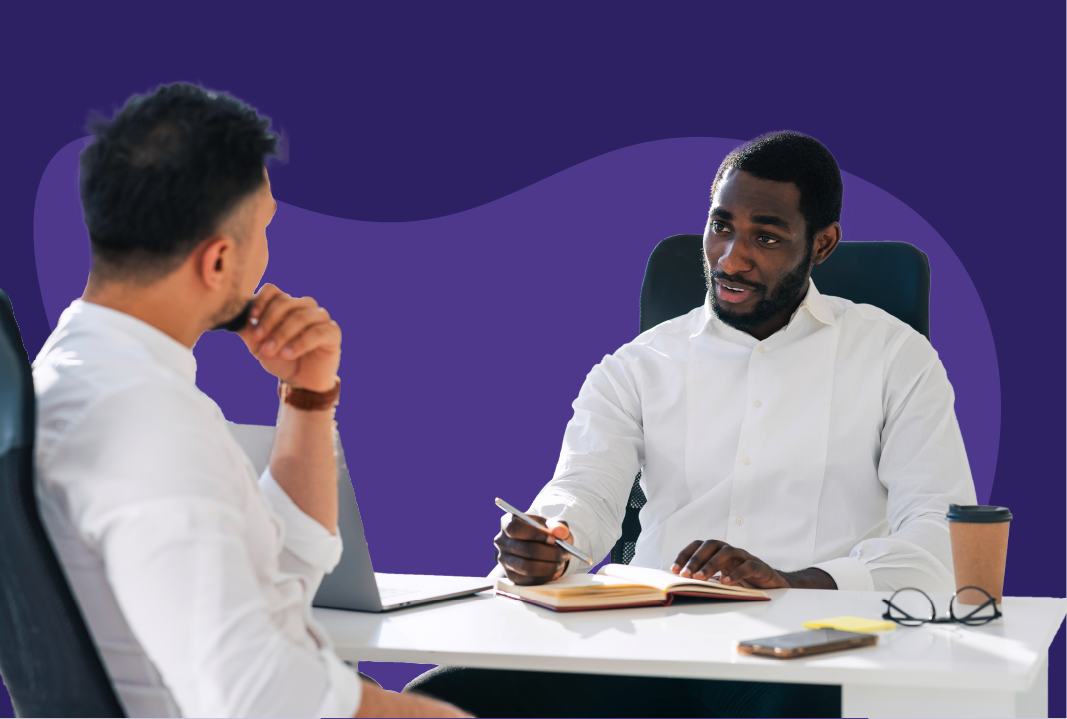 Two men having a discussion at an office table.