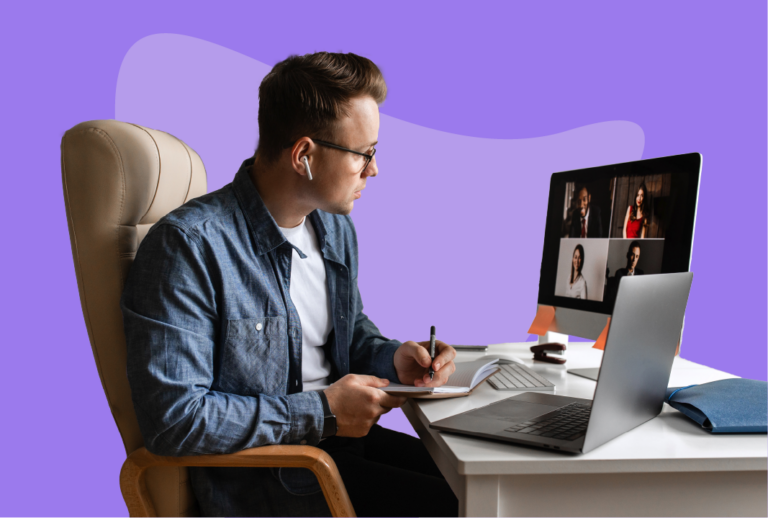 Man sitting at desk with laptop and second monitor