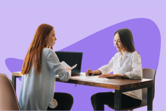Employer sitting across a plain desk from terminated employee.